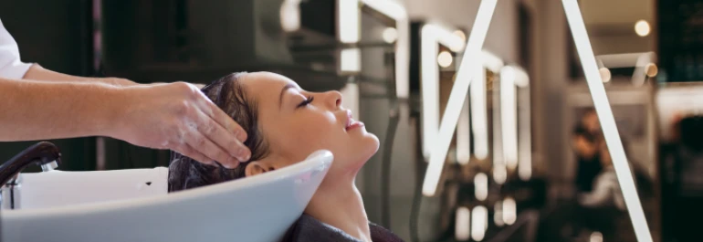  Una persona está recibiendo un lavado de cabello en una peluquería. 