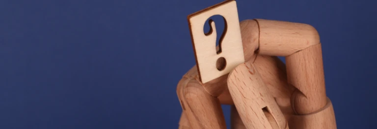  Mano de madera articulada sujetando una madera con interrogante 