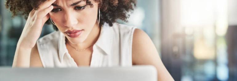  Una persona parece preocupada mientras mira una computadora portátil. 