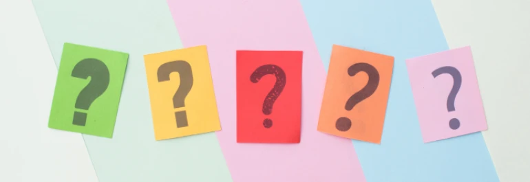  Cartulinas de varios colores son interrogantes negros sobre fondo de colores 