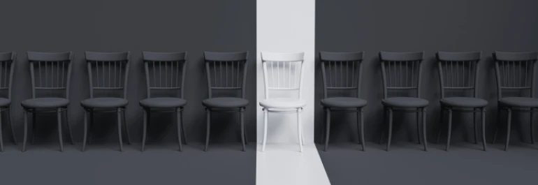  Una fila de sillas negras con una silla blanca en el centro. 