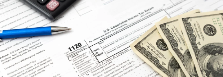  Formularios de impuestos, dinero en efectivo, una calculadora y un bolígrafo. 