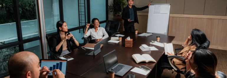  Personas participando en una reunión de trabajo en una sala de conferencias. 