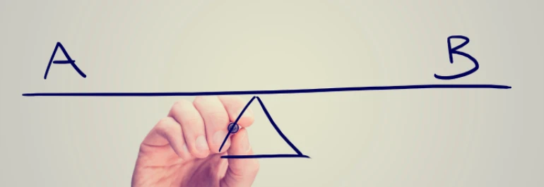  Una mano dibuja una balanza con los extremos etiquetados como A y B. 