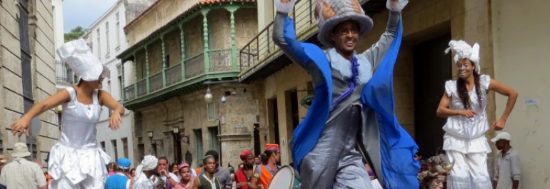  Personas disfrazadas desfilan en una calle concurrida. 