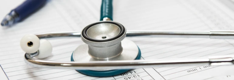  Fonendoscopio sobre horario junto a boli 