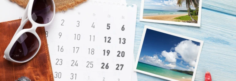  Un calendario, fotos de playa, gafas de sol y un sombrero sugieren planificación de vacaciones. 