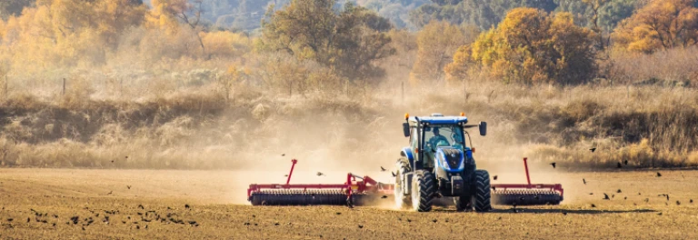  Tractor azul en campo de siembra en otoño 