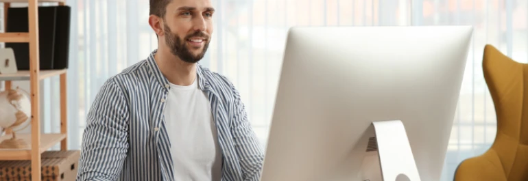  Una persona está sentada frente a una computadora en un entorno de oficina. 