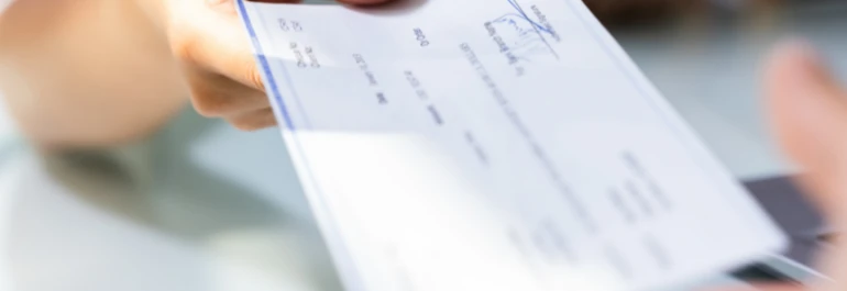  Una persona entrega un cheque a otra persona. 