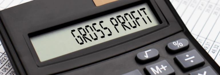  Una calculadora muestra GROSS PROFIT sobre una hoja de cálculo financiera. 
