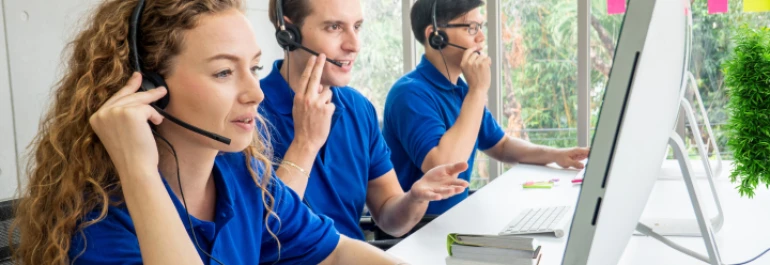  Personas con auriculares trabajando en un centro de atención al cliente. 