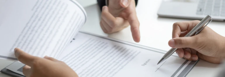  Dos personas están revisando y firmando documentos. 