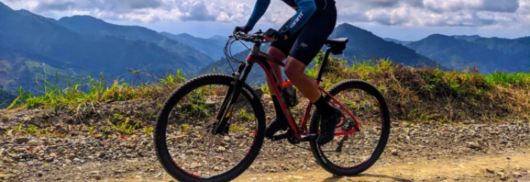  Hombre con indumentaria deportiva montando bicicleta de montaña roja 