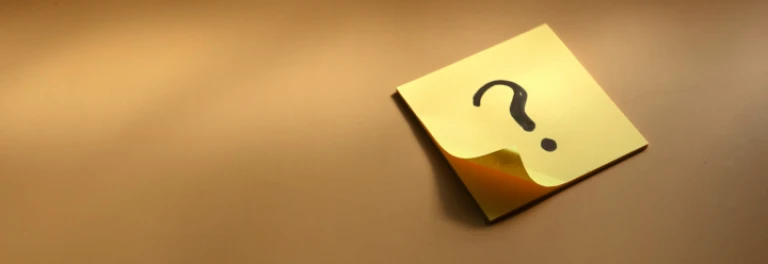  Post it amarillo con un interrogante sobre fondo ocre 