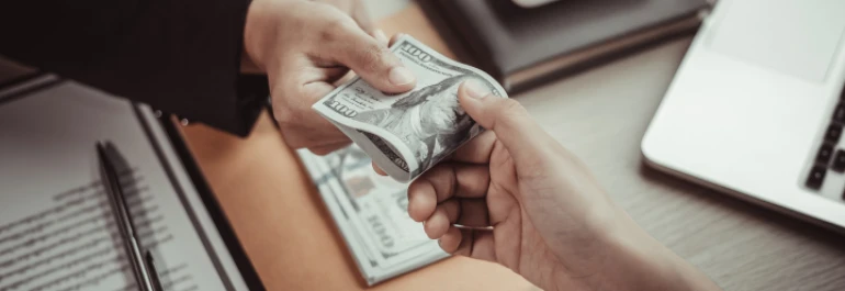  Una persona le entrega dinero a otra en una oficina. 