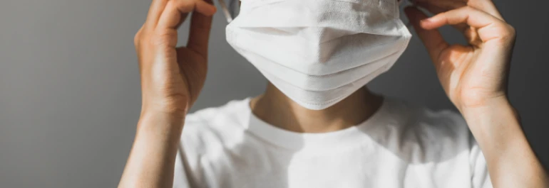  Persona ajustándose una mascarilla blanca. 