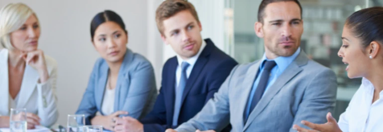  Un grupo de personas en traje discute en una reunión. 