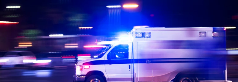  Una ambulancia circula rápidamente con las luces encendidas por la noche. 