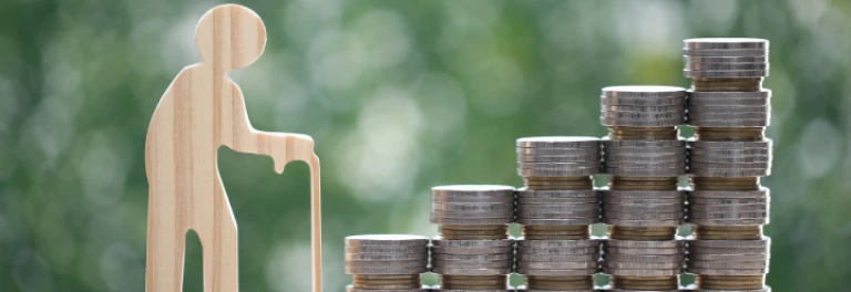  Silueta de anciano de madera con montones de monedas 