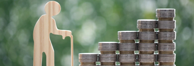  Silueta de anciano de madera con montones de monedas 