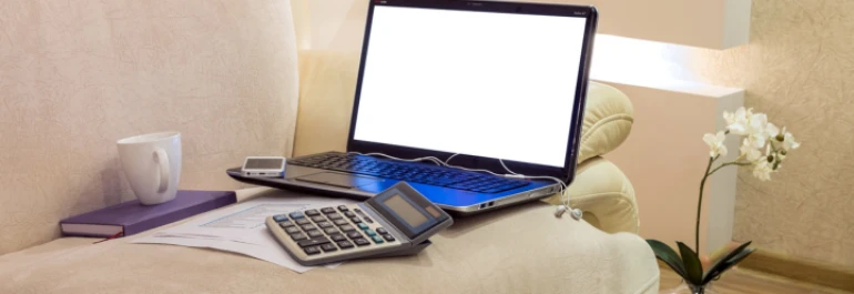  Sofá blanco con portátil, agenda, calculadora, móvil, papeles y auriculares 
