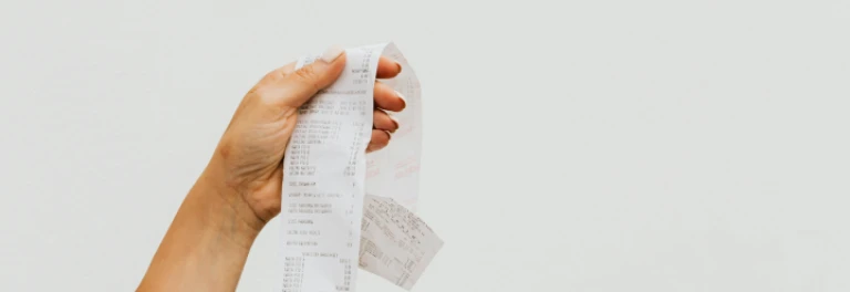  Mano femenina sujetando una factura frente a fondo blanco 
