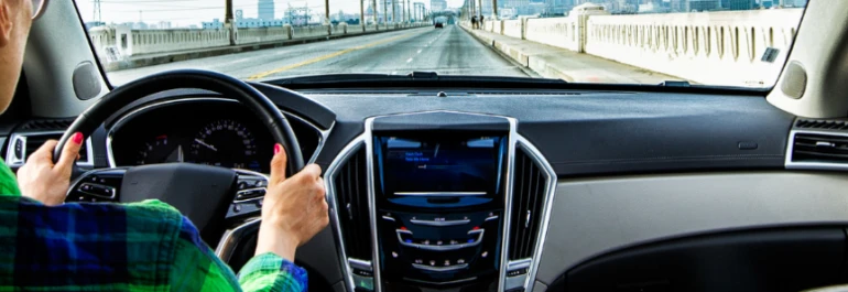  Una persona conduce un automóvil por un puente vació con vista hacia la carretera. 