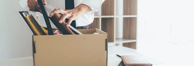  manos empacando sus cosas en una oficina 