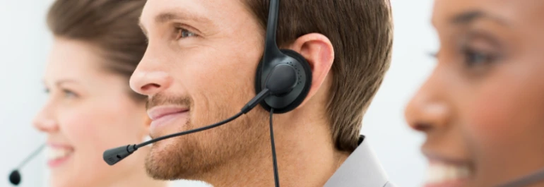  Tres personas con auriculares trabajan en atención al cliente. 