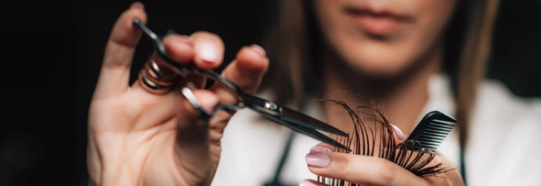  Una persona cortando cabello con tijeras y peine. 