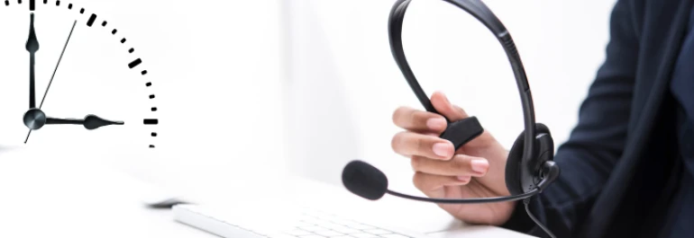  Una persona sostiene unos auriculares delante de un teclado con un reloj gráfico a la izquierda. 