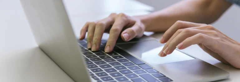  Una persona está escribiendo en una computadora portátil. 