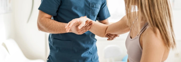  Un profesional de la salud examina el brazo de una mujer. 