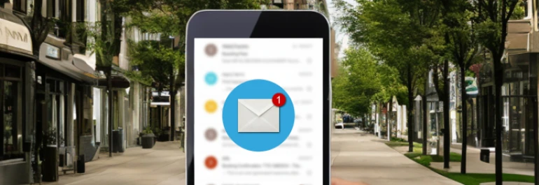  Un teléfono móvil muestra una notificación de correo nuevo mientras se sostiene en un entorno urbano. 