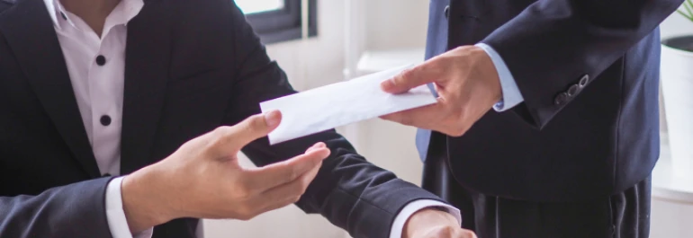  Una persona entregándole un sobre a otra persona en un entorno formal. 