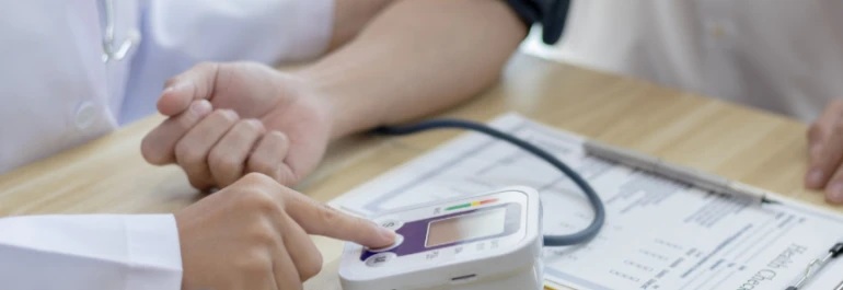 Un médico mide la presión arterial de una persona con un tensiómetro en una consulta. 