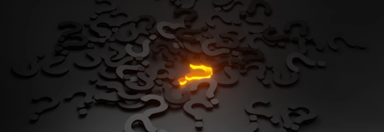  Signos de interrogación regados por el suelo, con uno de ellos brillando en amarillo 