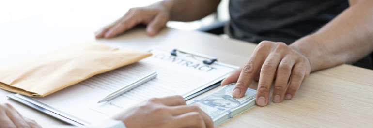  Dos personas están intercambiando dinero sobre un contrato. 