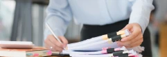  Persona firmando montón de documentos en una oficina 
