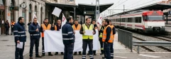  Trabajadores en huelga en empresa ferroviaria con el tren detrás 