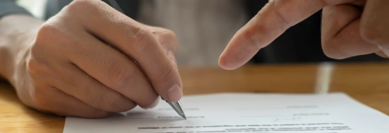  Mano señalando con el dedo a otra dónde firmar 