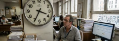  trabajador en la oficina con reloj de fondo que marca el paso del tiempo 