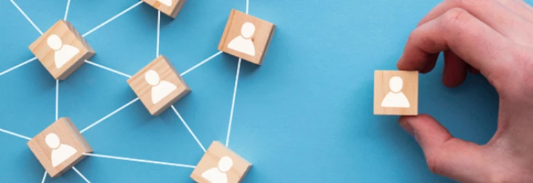  Fichas de madera con un siluetas de personas pintadas en blanco unidas por un hilo menos una 